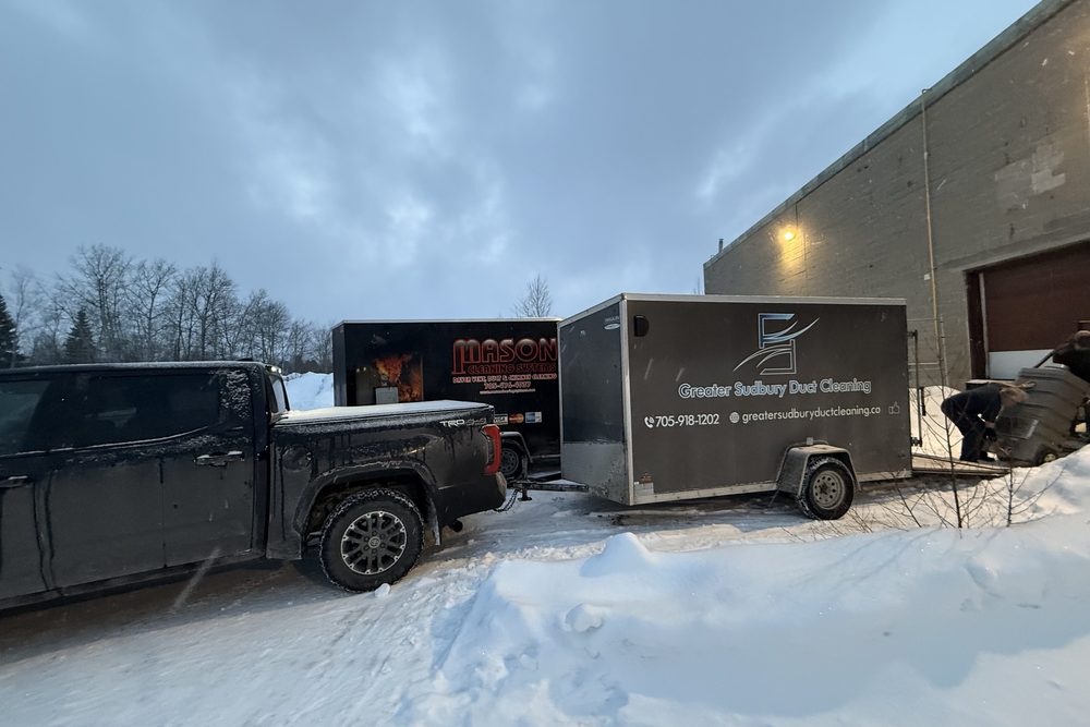 Greater Sudbury Duct Cleaning truck and trailers at a commercial building in winter
